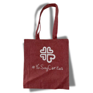 Bolsa de tejido de algodón en rojo-fresa con logo de Caritas y hashtag #YoSoyCáritas en blanco